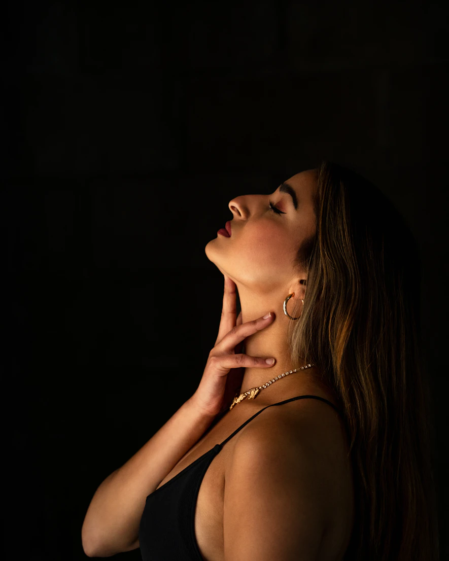 Woman in profile touching her jawline