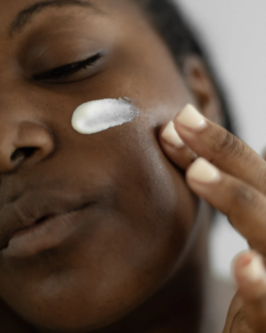Woman applying moisturiser to her face